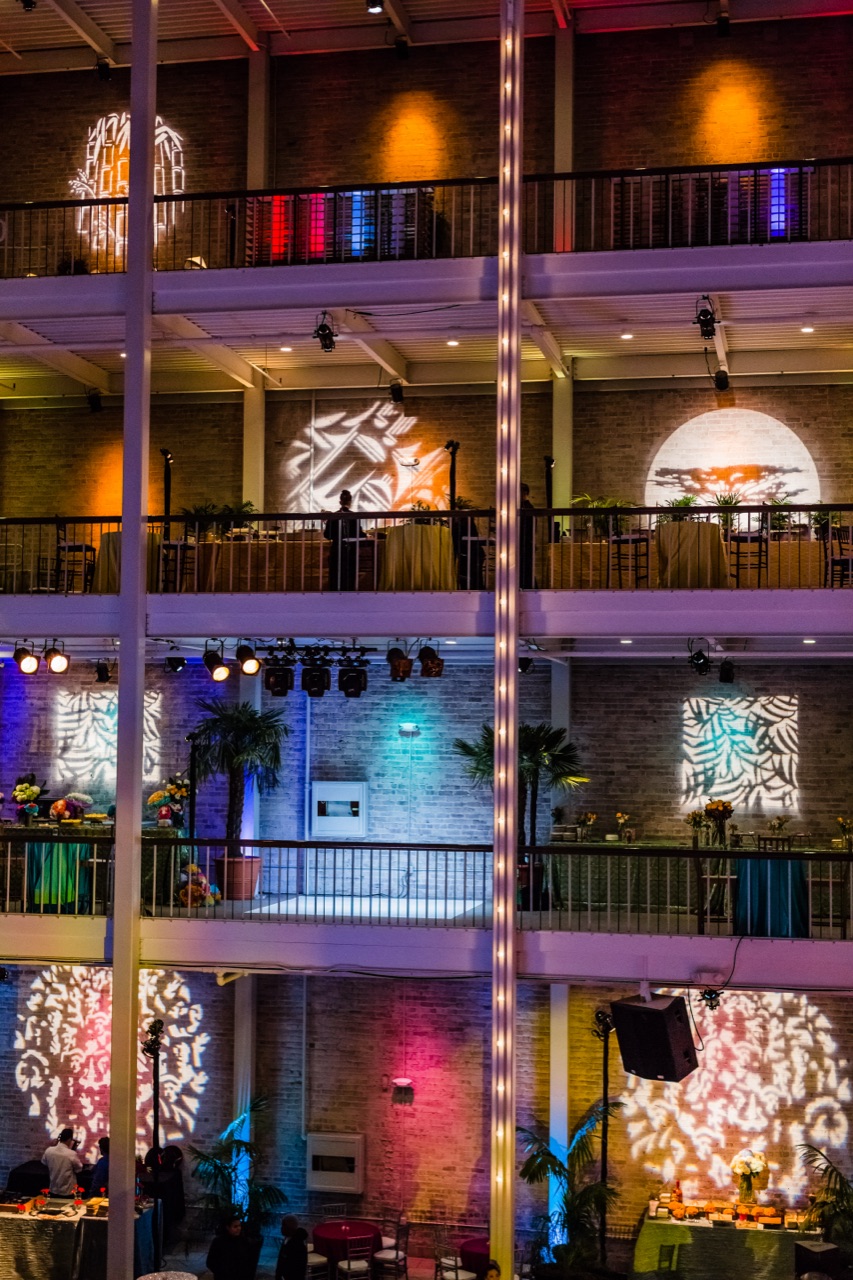 Impact's colorful uplighting and leaf gobo patterns wash the brick balconies of a multi-level atrium event.