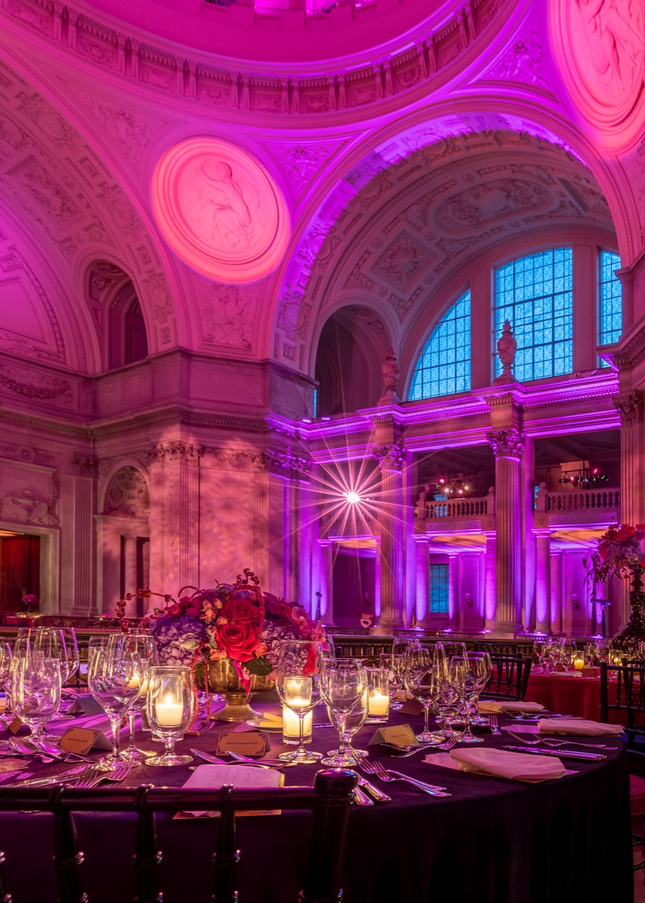 Impact's magenta uplighting and a pinspot gobo starburst fill the San Francisco City Hall rotunda above a candlelit ballet gala dinner.