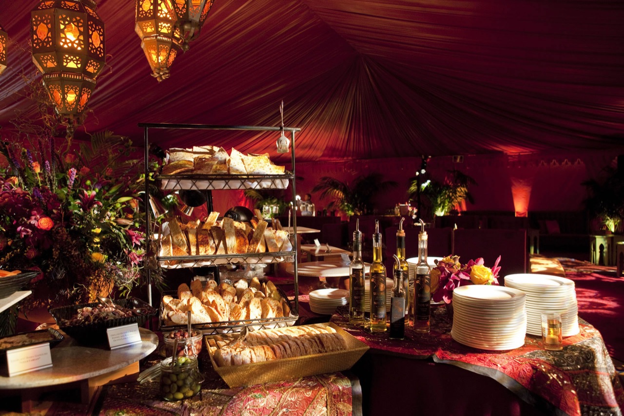 Impact pinspotted a lavish buffet inside a red Moroccan tent lit by ornate hanging lanterns and floral accents.