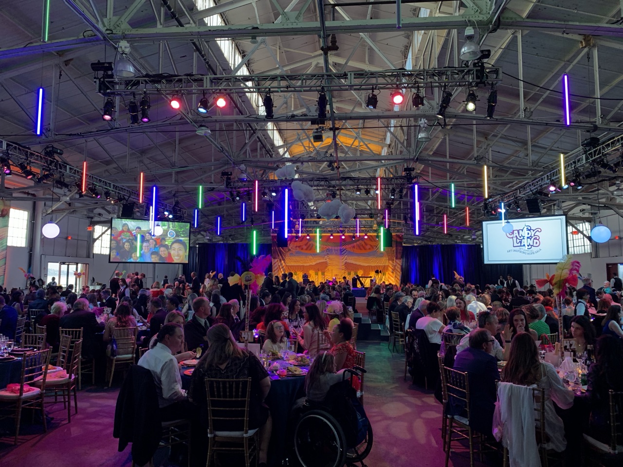Colorful LED tubes and moving lights wash a large gala dinner in a Fort Mason hall produced by Impact.