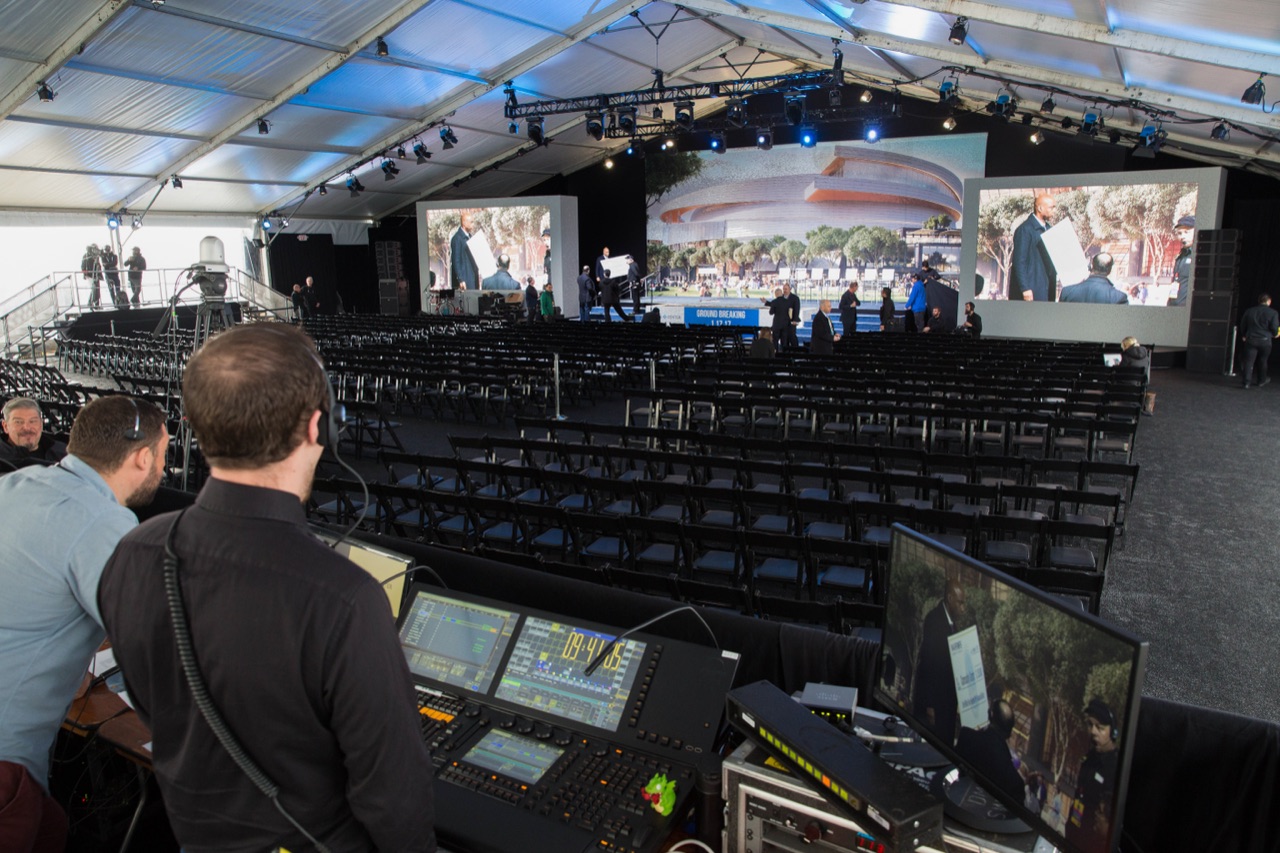 Impact's front-of-house crew runs lighting and audio consoles facing the staged seating at the Warriors Chase Center groundbreaking.