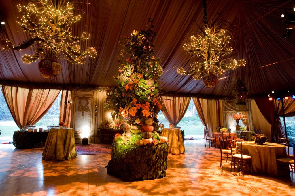 Fairy-light chandelier trees and warm draping light Impact's autumn-themed tented reception with a gobo-patterned dance floor.
