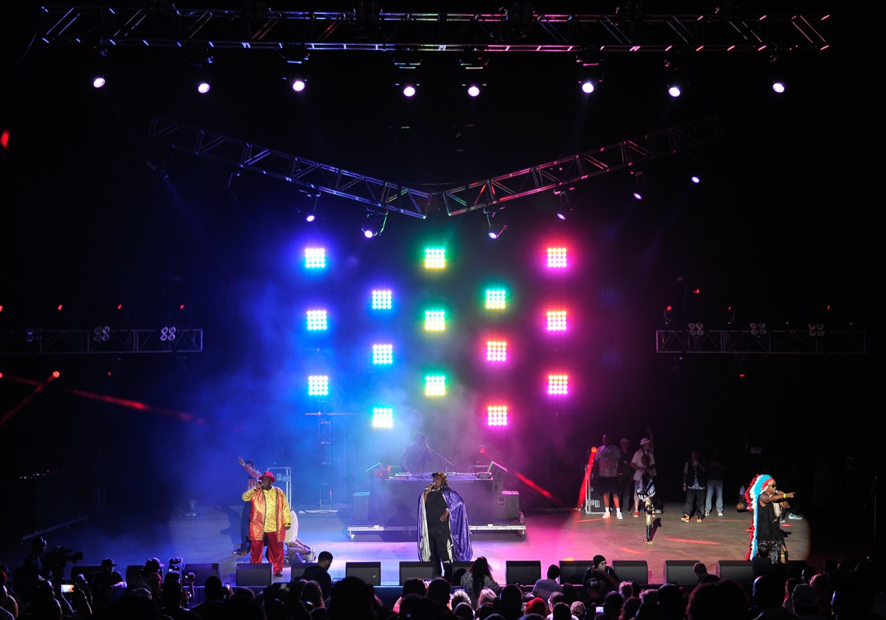 Impact's rainbow LED panel wall, truss rig, and haze back a live concert performance on a production stage.