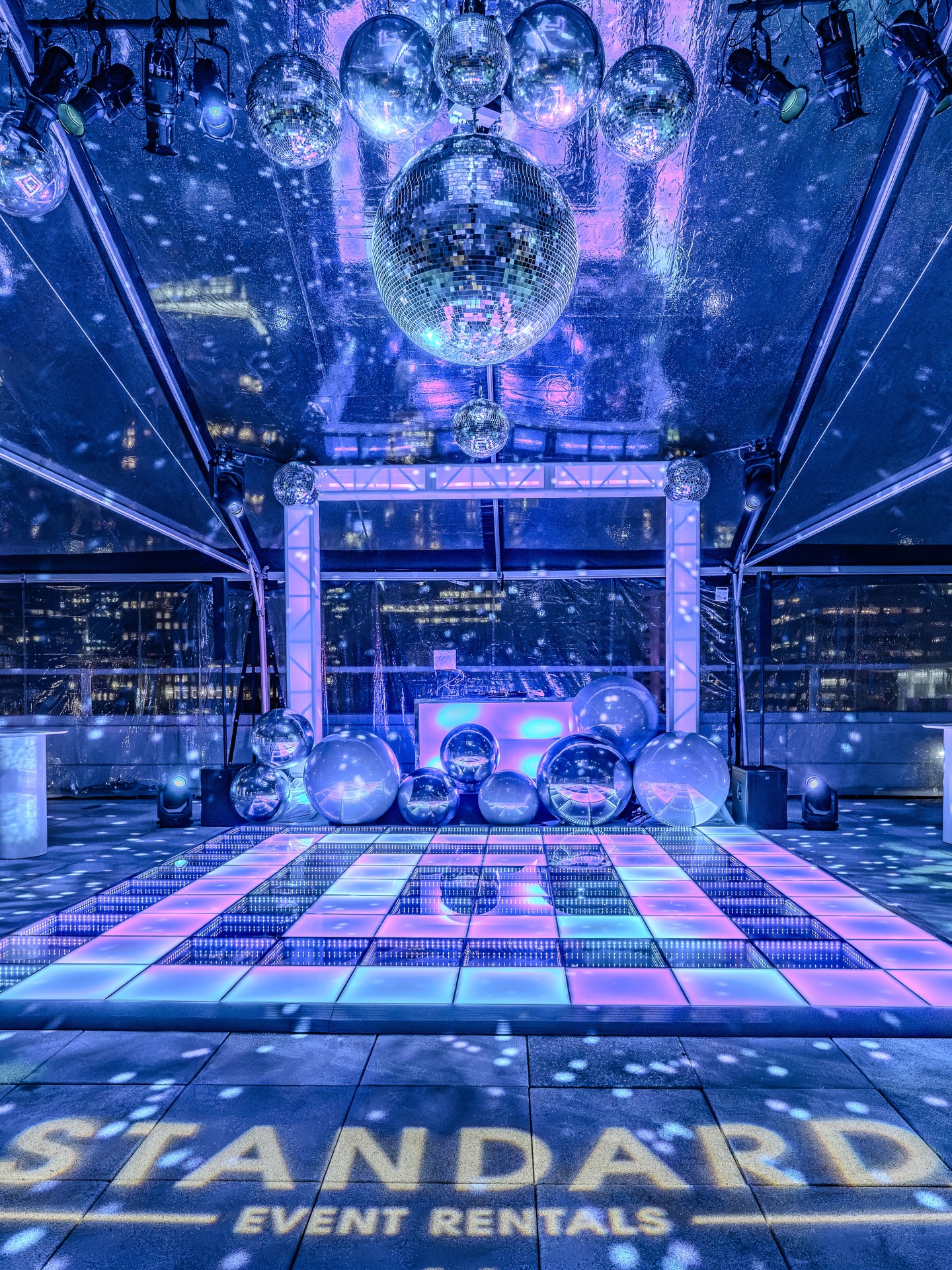 Infinity dance floor under a canopy of disco balls in a clear-top rooftop tent