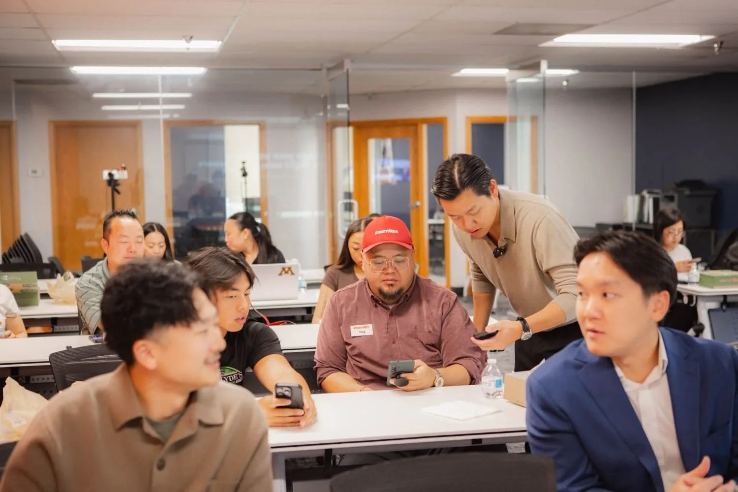 Christian Yang working one-on-one with a local business owner on his phone during a workshop