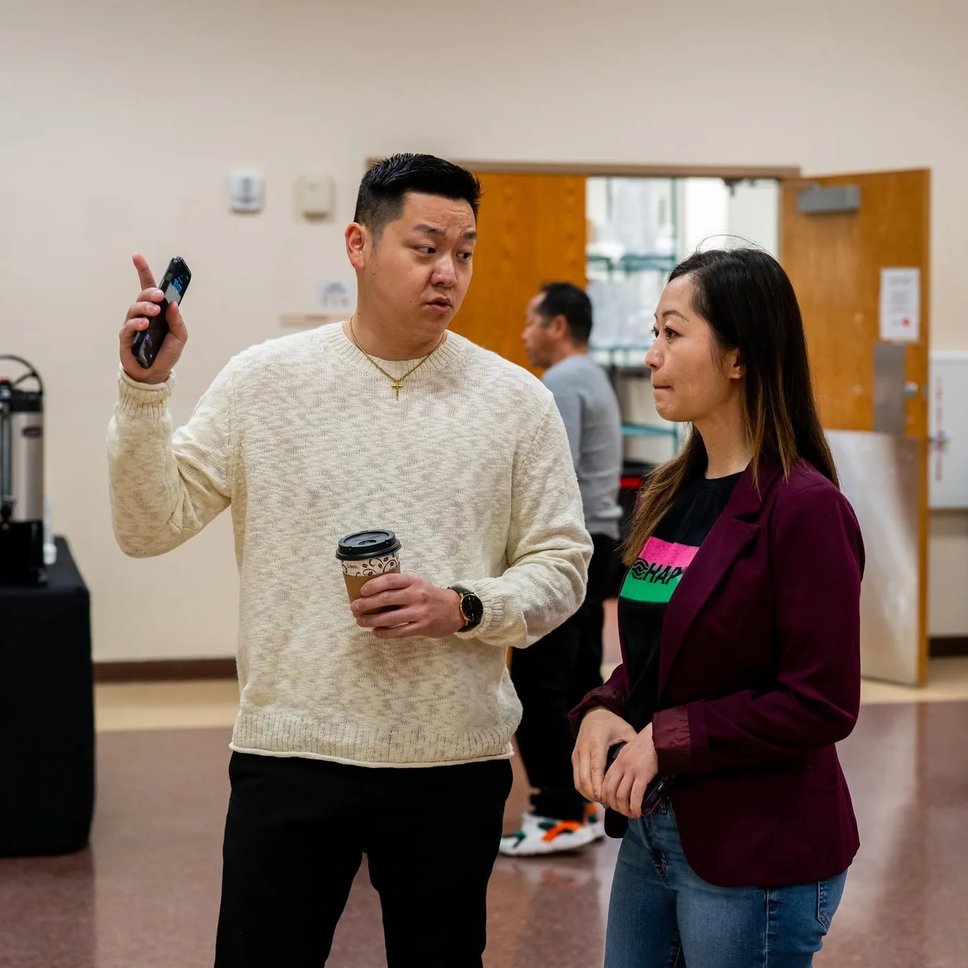 Christian Yang working with a Hmong American Partnership staff member at a community event