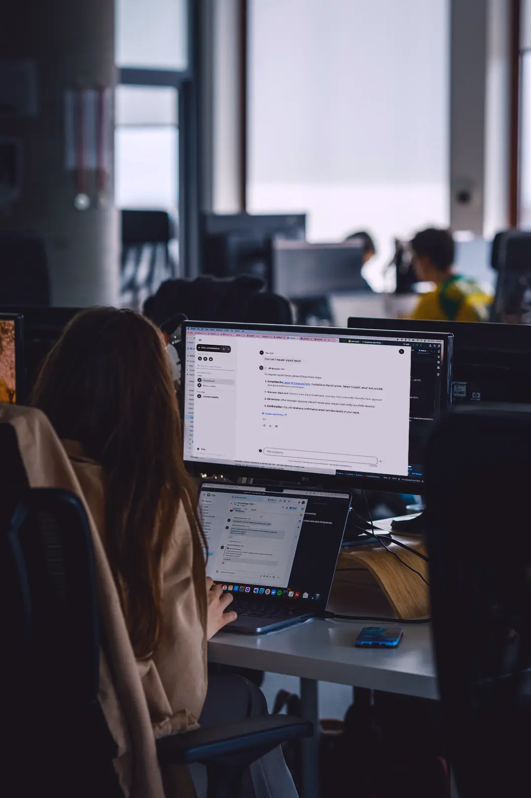 Woman in an office using Knowledge Chat on her computer.