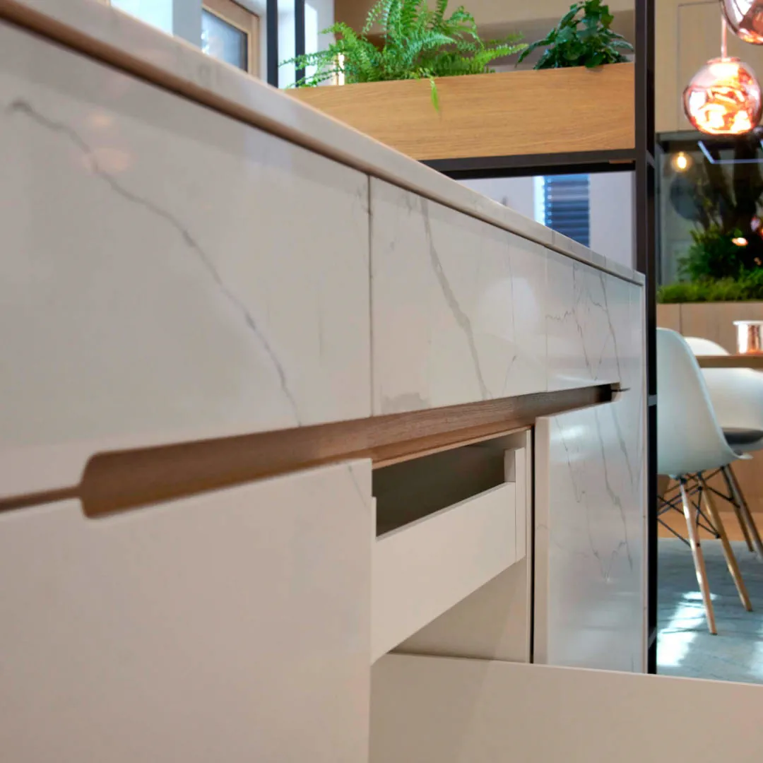 Designový průřez v sestavě odolných keramických nábytkových dvířek v designu mramoru vytváří prostor pro úchyt.