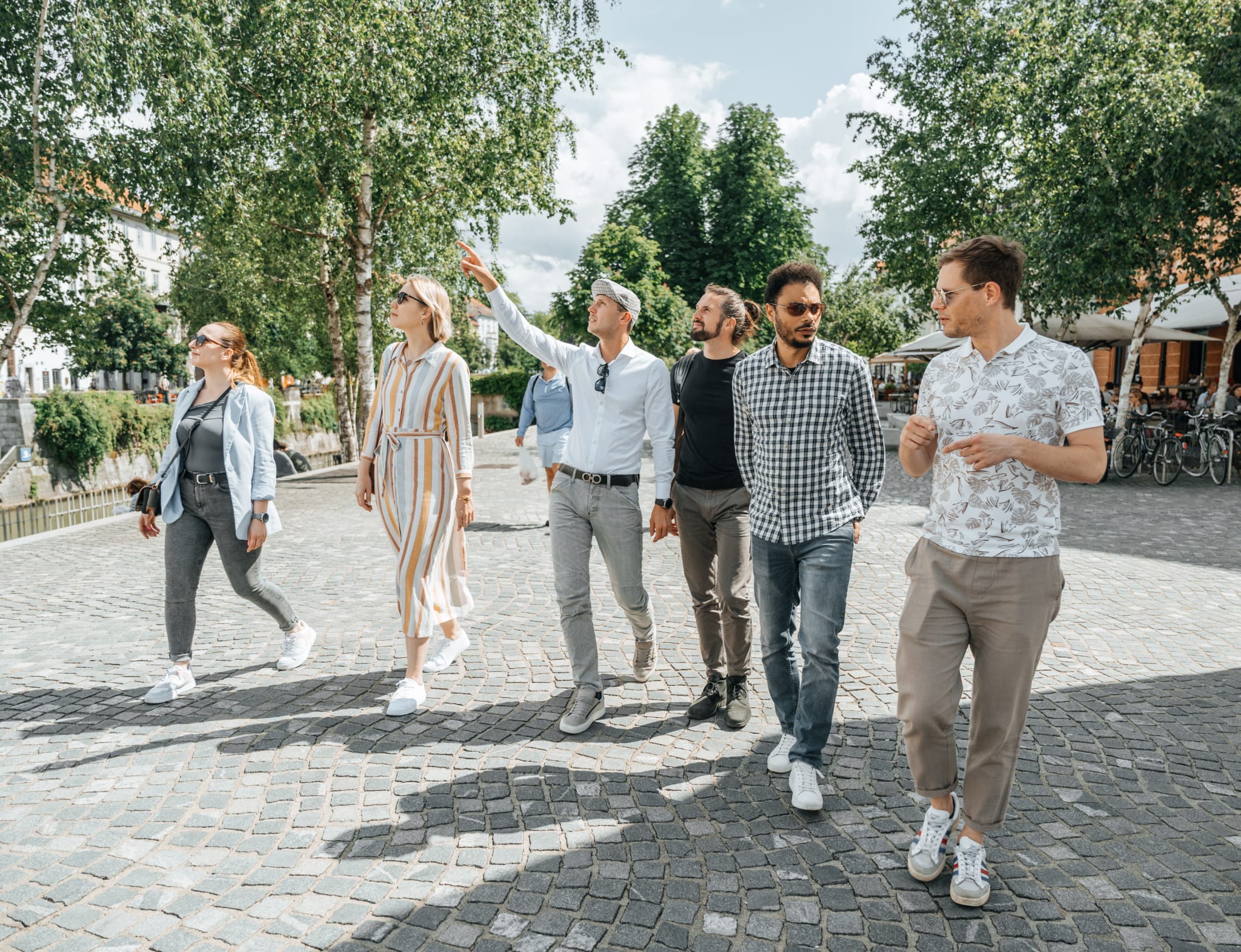 Sigismundi guide leading an engaging, high-end city walking tour for a group through a picturesque urban landscape.