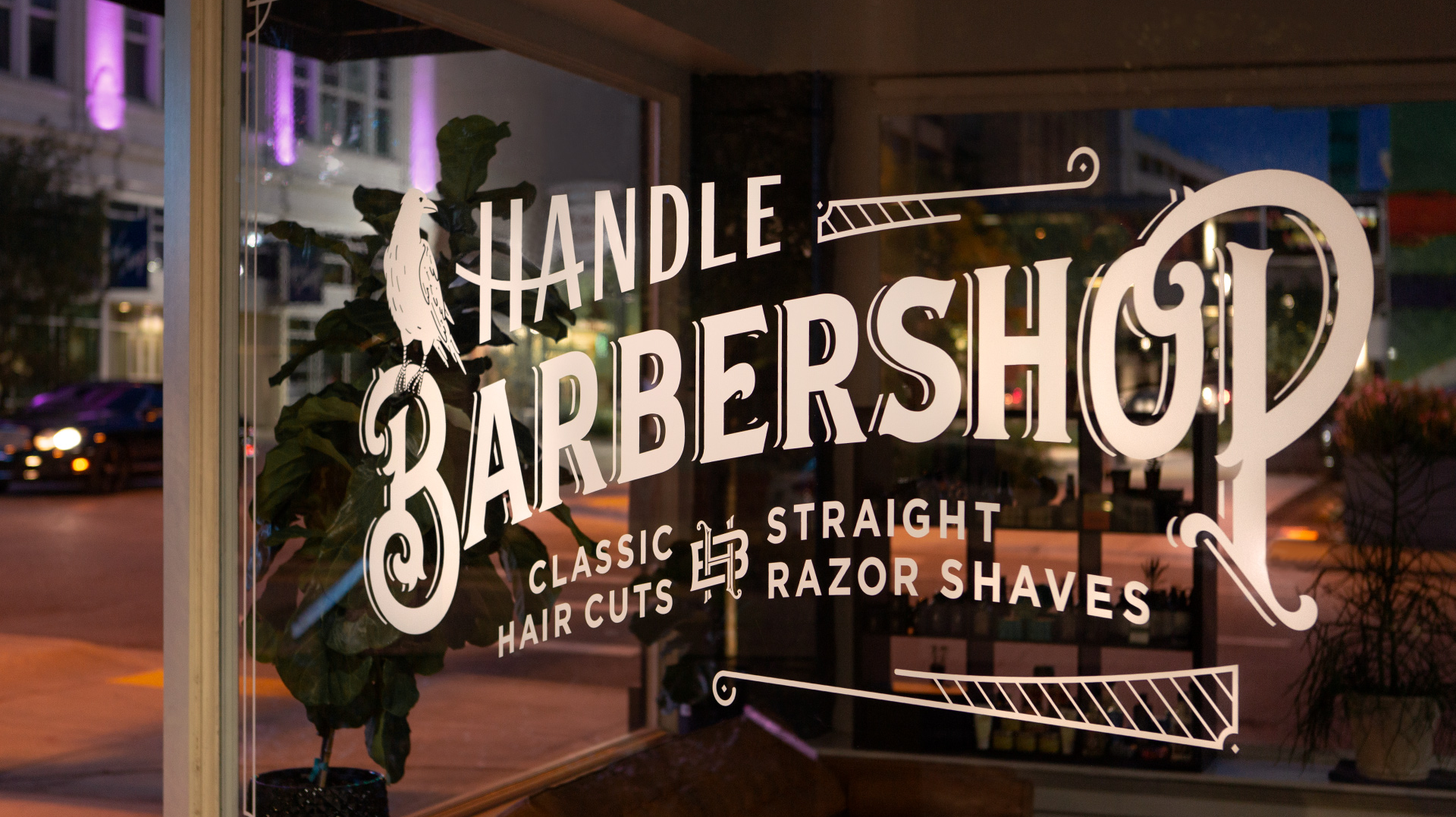 Victorian-inspired window detail window design install and branding with illustrated raven, for Handle Barbershop in Little Rock, Arkansas.