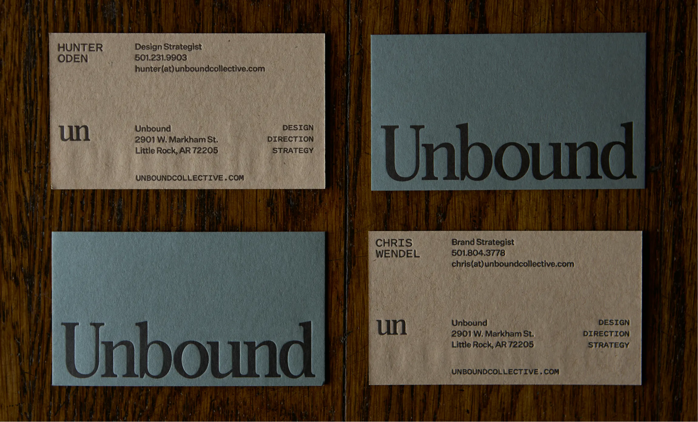 Unbound Collective business cards for Hunter Oden and Chris Wendel in kraft and sage blue colorways with letterpress typography on dark wood surface, brand identity by Unbound Collective