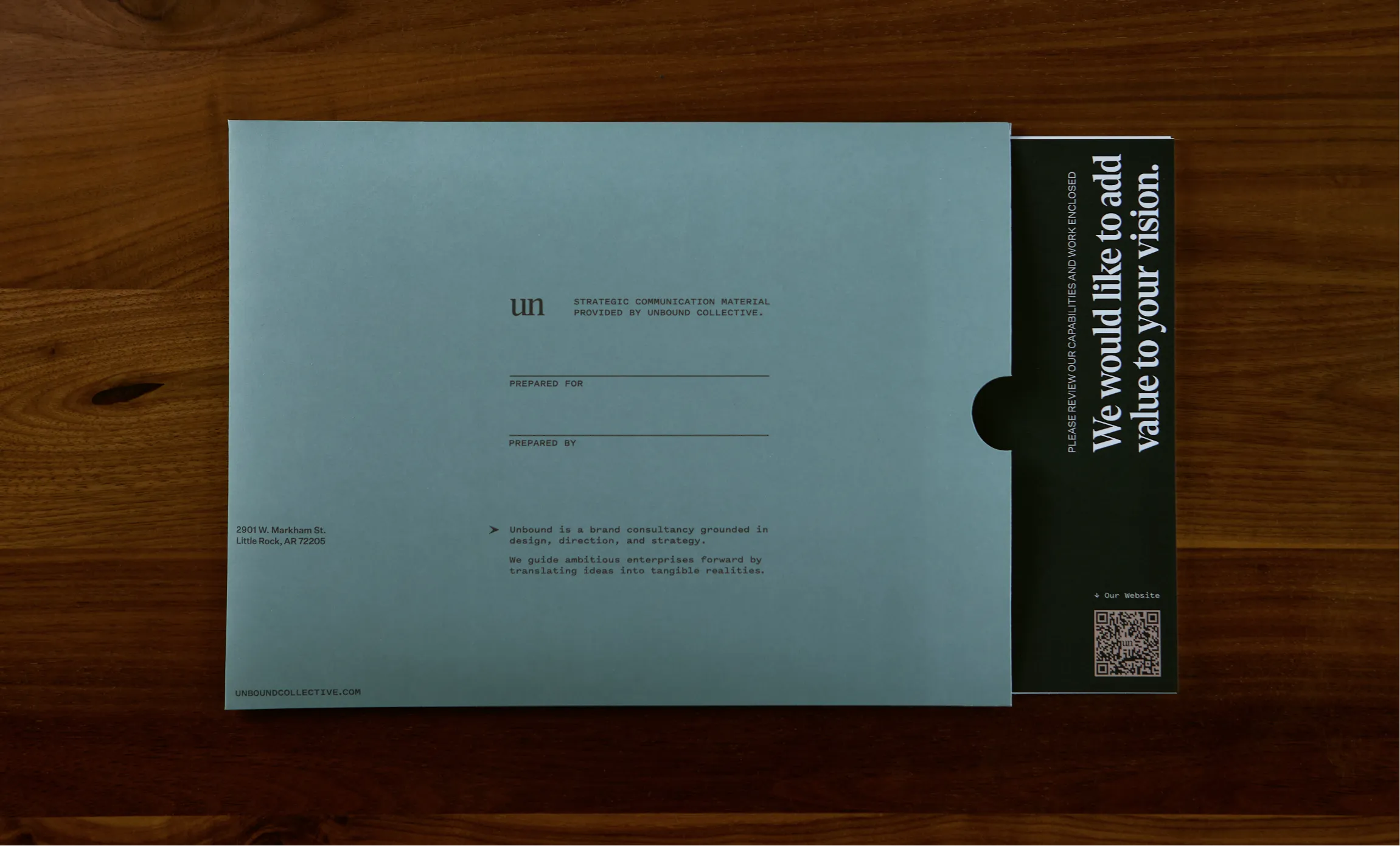Unbound Collective kraft and slate business cards for Hunter Oden displayed in industrial metal card holders against a brick wall background, print design by Unbound Collective