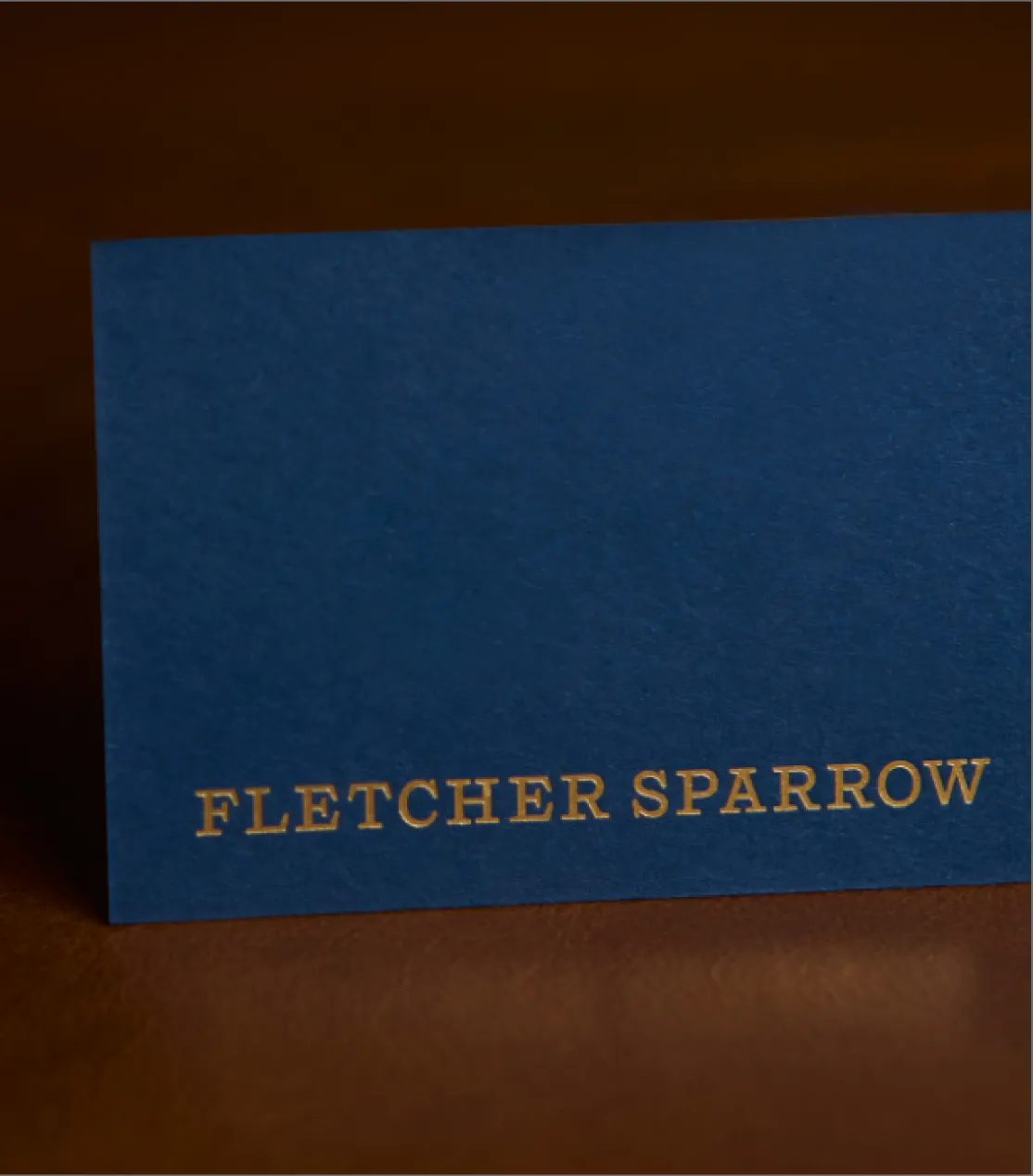 Fletcher Sparrow navy blue business card with gold foil embossed serif wordmark, premium print and brand identity design by Unbound Collective