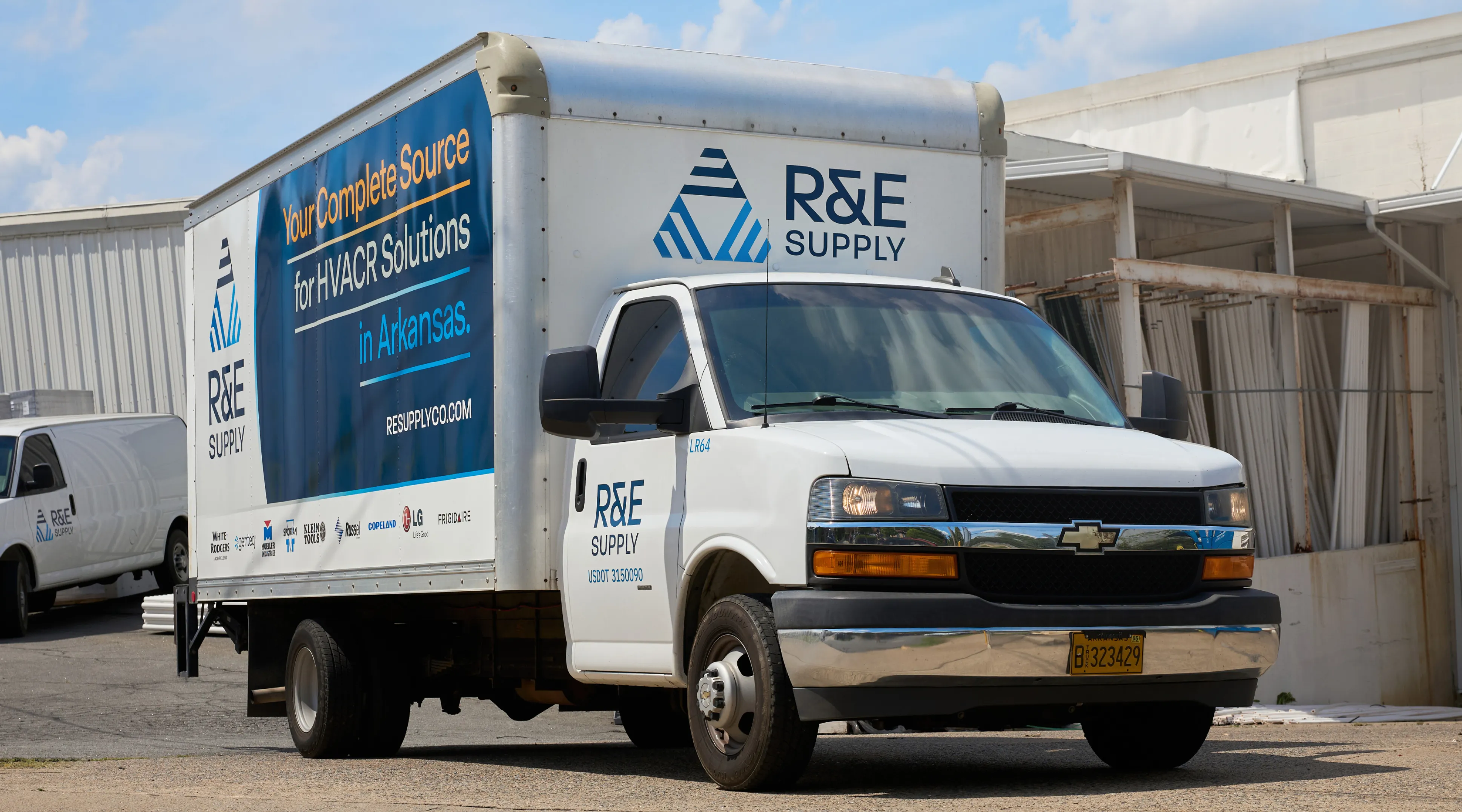R&E Supply branded Chevrolet box truck with Your Complete Source for HVACR Solutions in Arkansas vehicle wrap photographed from front angle at warehouse, vehicle branding by Unbound Collective