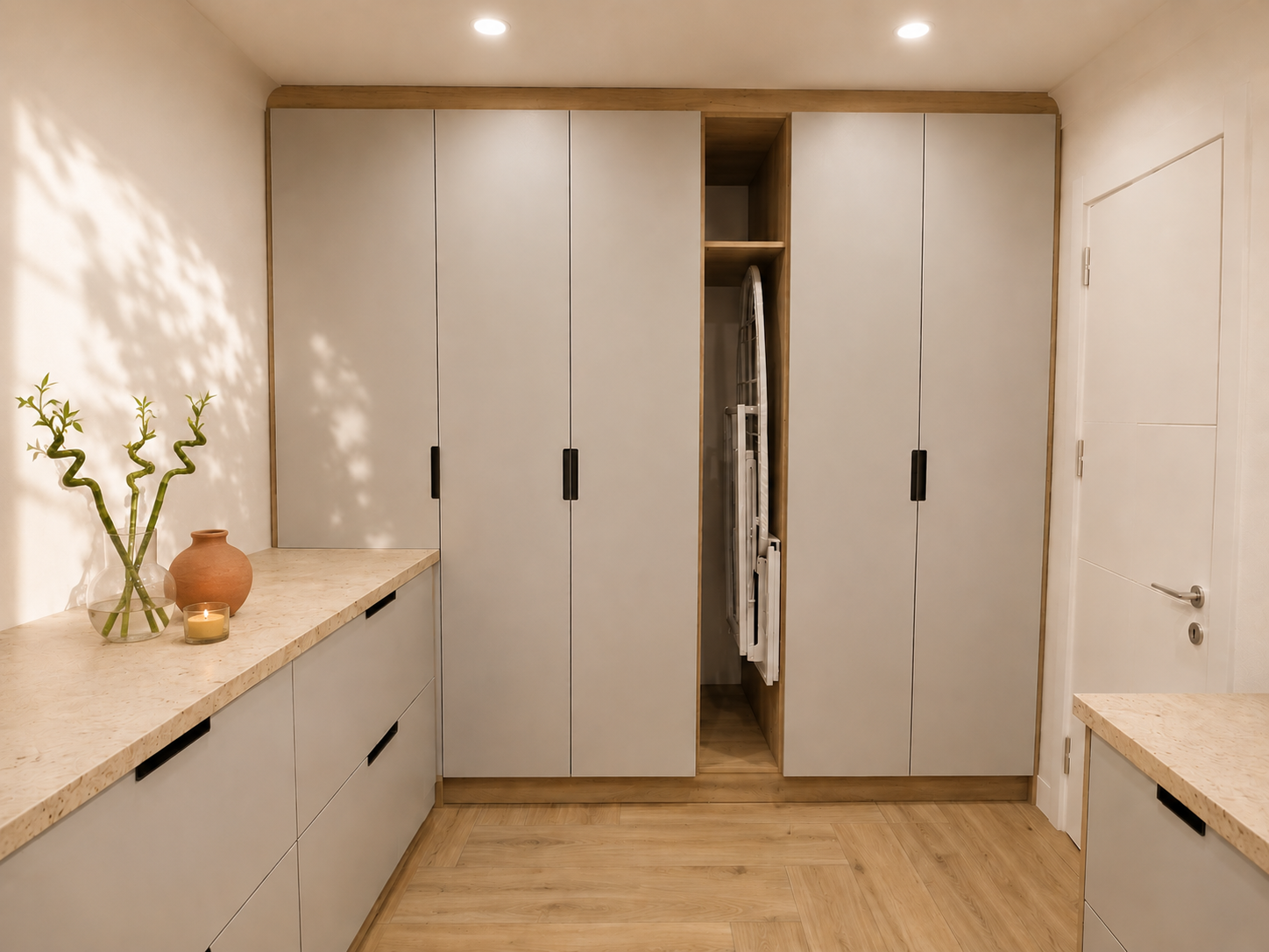 Modern beige storage room with built-in cabinets, bamboo plant, clay vase, and lit candle on countertop.