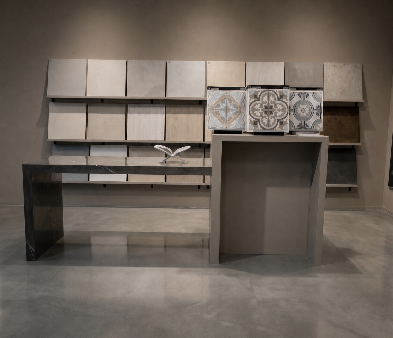 Materialvägg med kakelprover, svart marmorkonsol och mönstrad cementkakel i HT:s showroom.