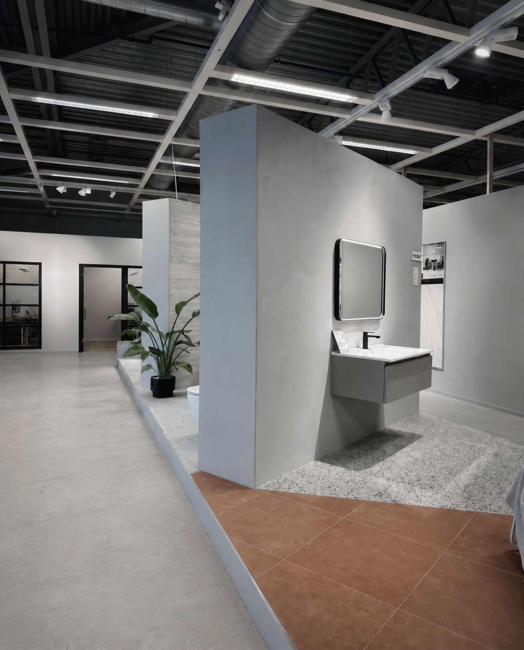 Översikt av HT:s showroom med betongfond, svävande kommod och golvzoner i terrazzo och terrakotta.