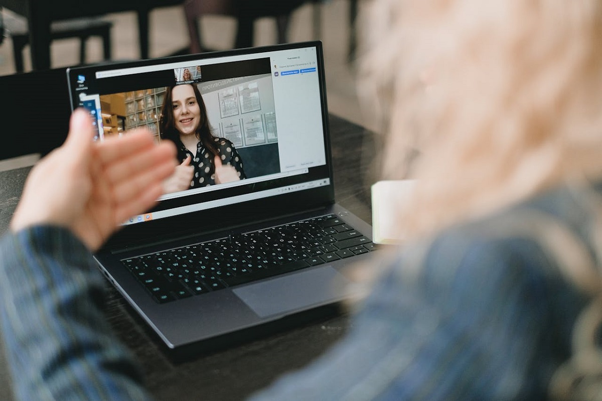 Woman sitting in front of her computer on a video call gesturing with her hands
