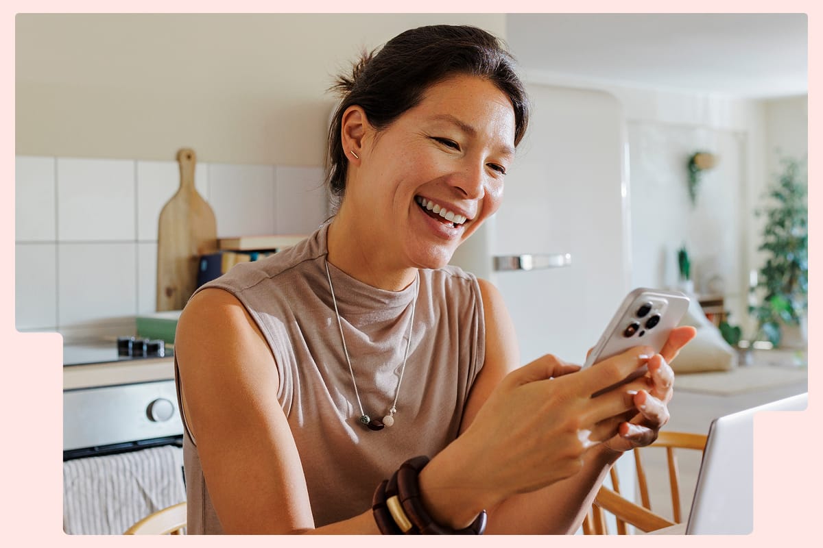 Woman looking at her phone in the kitchen