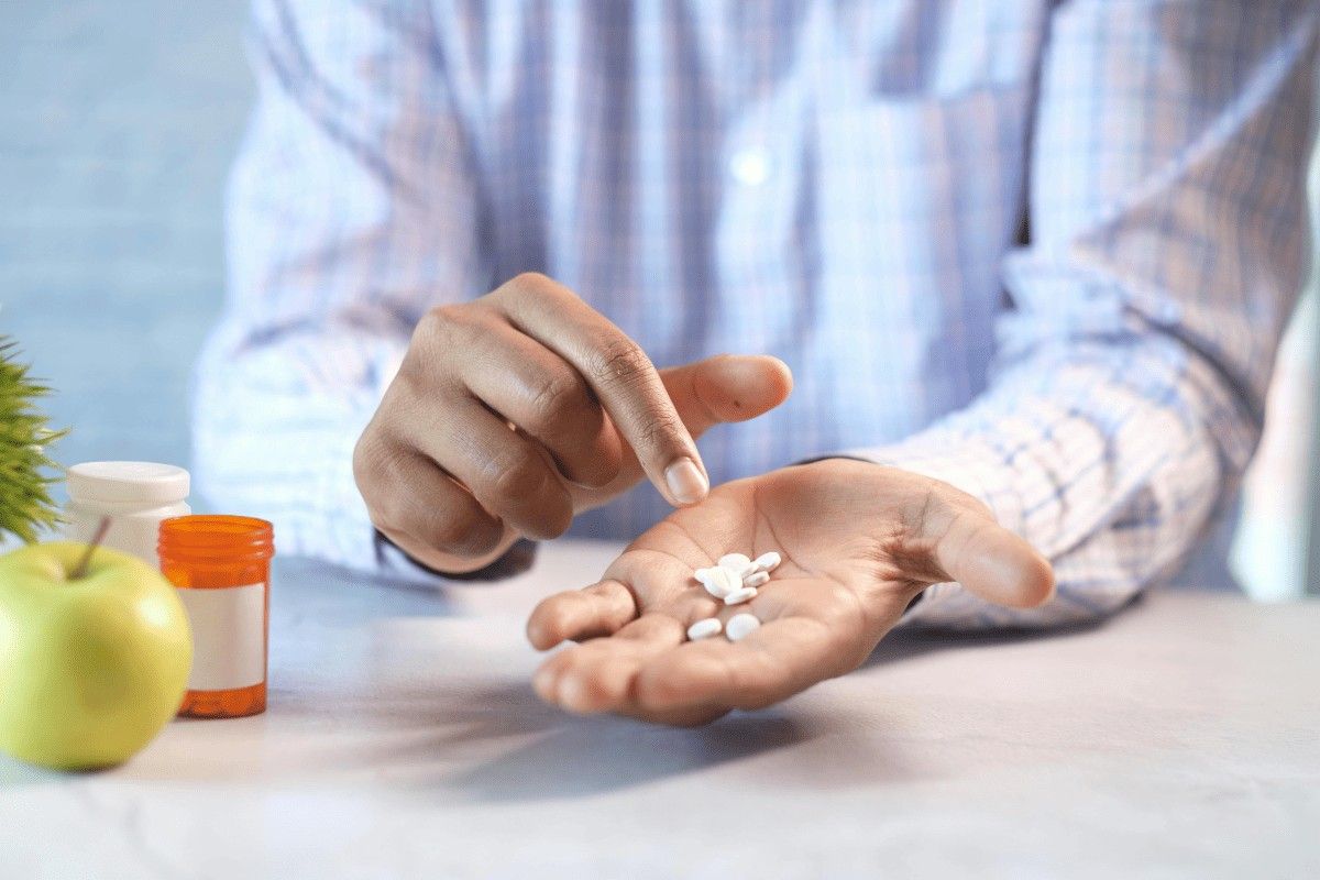 A person holding pills in his hand