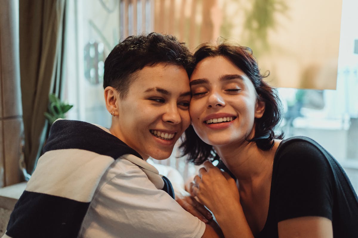 Happy LGBTQ couple smiling at the camera indoors