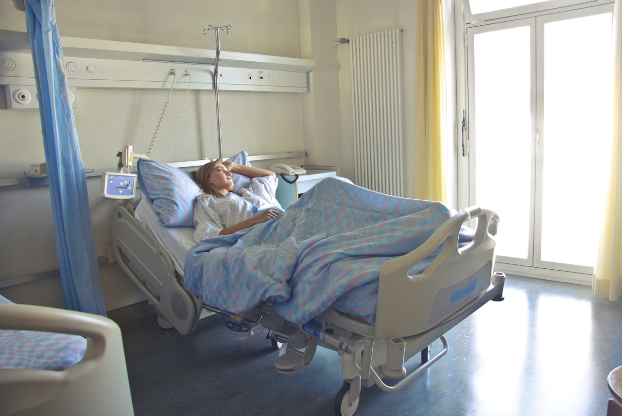 Woman laying in a hospital bed looking out the window