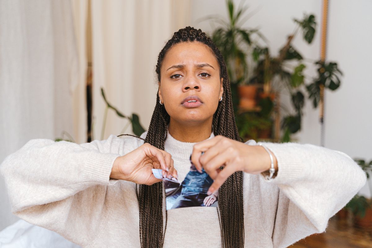 A lady tearing a photograph