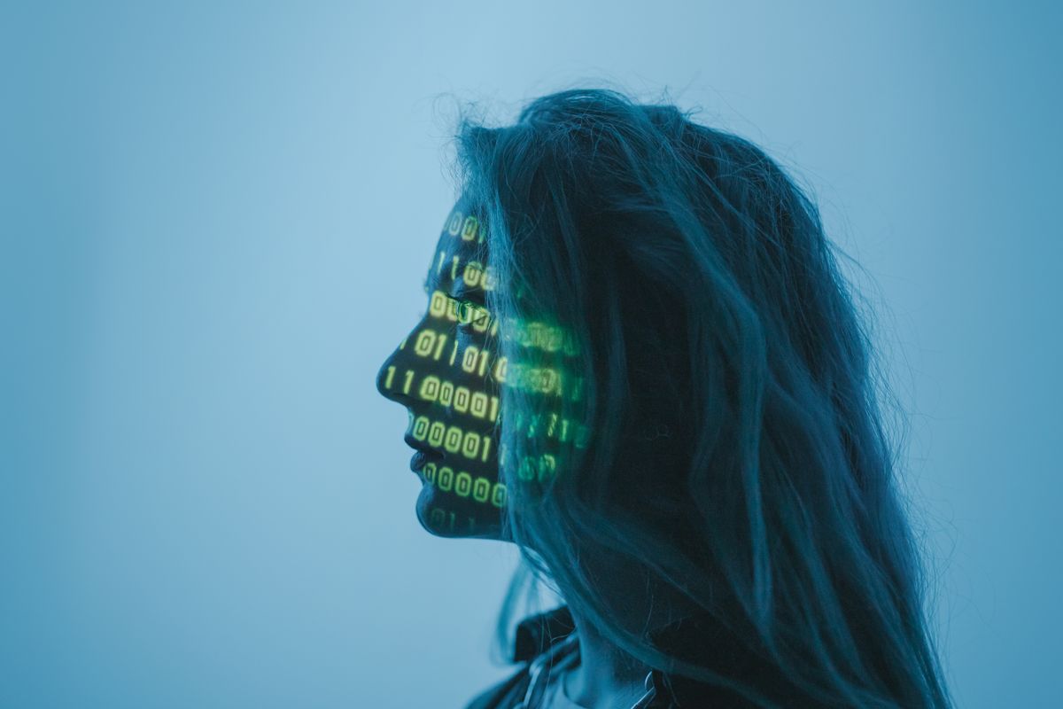 A person in profile with green binary code projected.