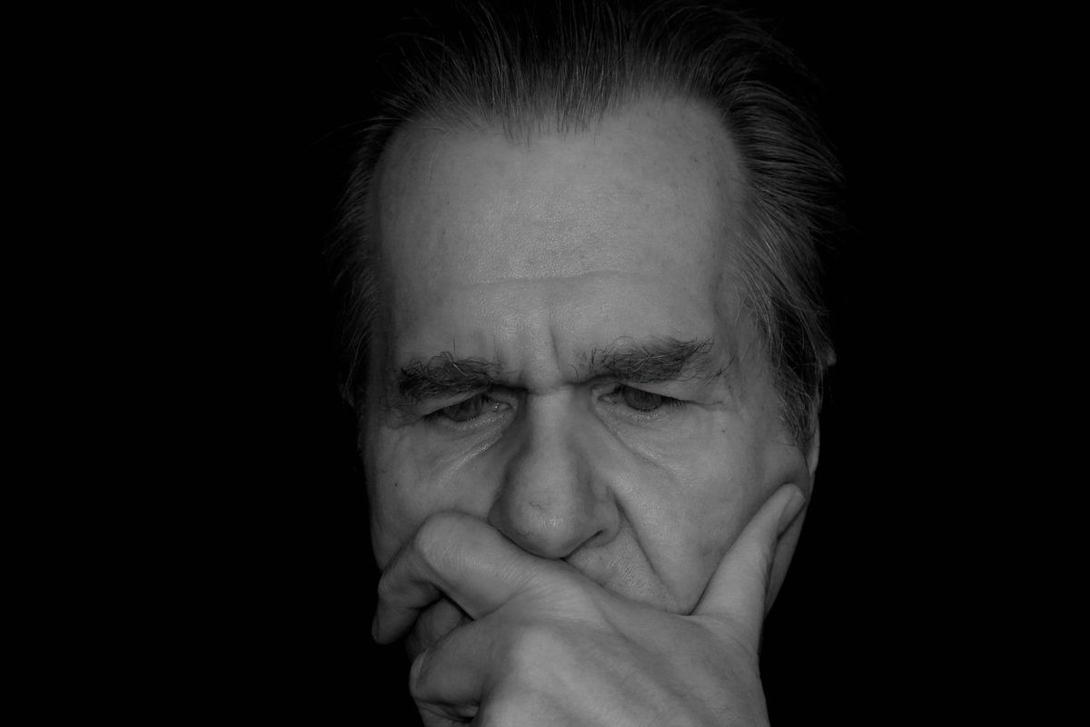 The image shows a grayscale, close-up photograph of a man's face.