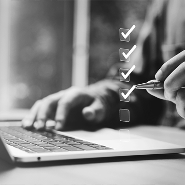 Man sitting at a desk in front of laptop checking floating checkboxes