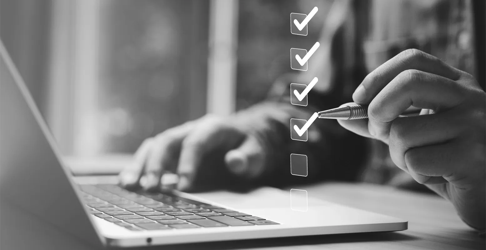 Man sitting at a desk in front of laptop checking floating checkboxes