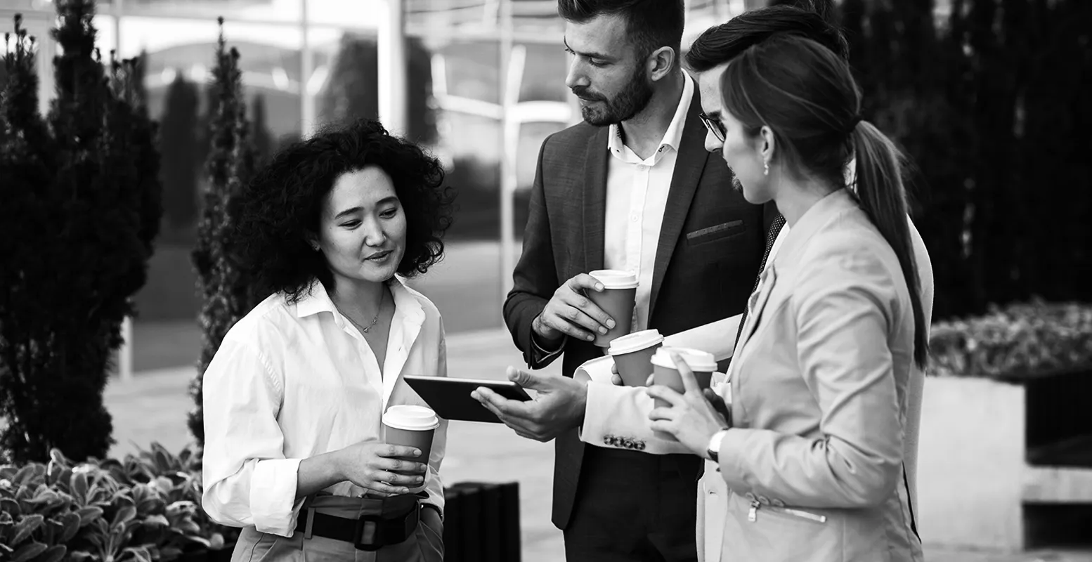 Group of business professionals talking and looking at an iPad