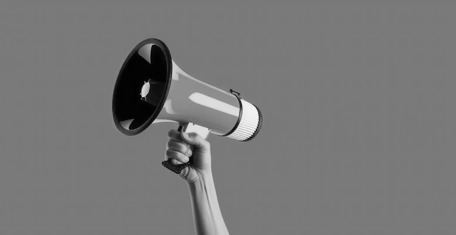 Hand holding up a megaphone on a solid color background