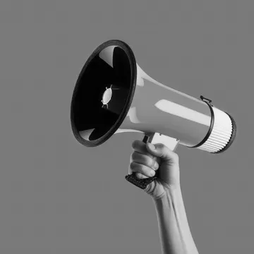 Hand holding up a megaphone on a solid color background
