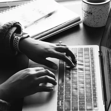 Hands of person working on laptop