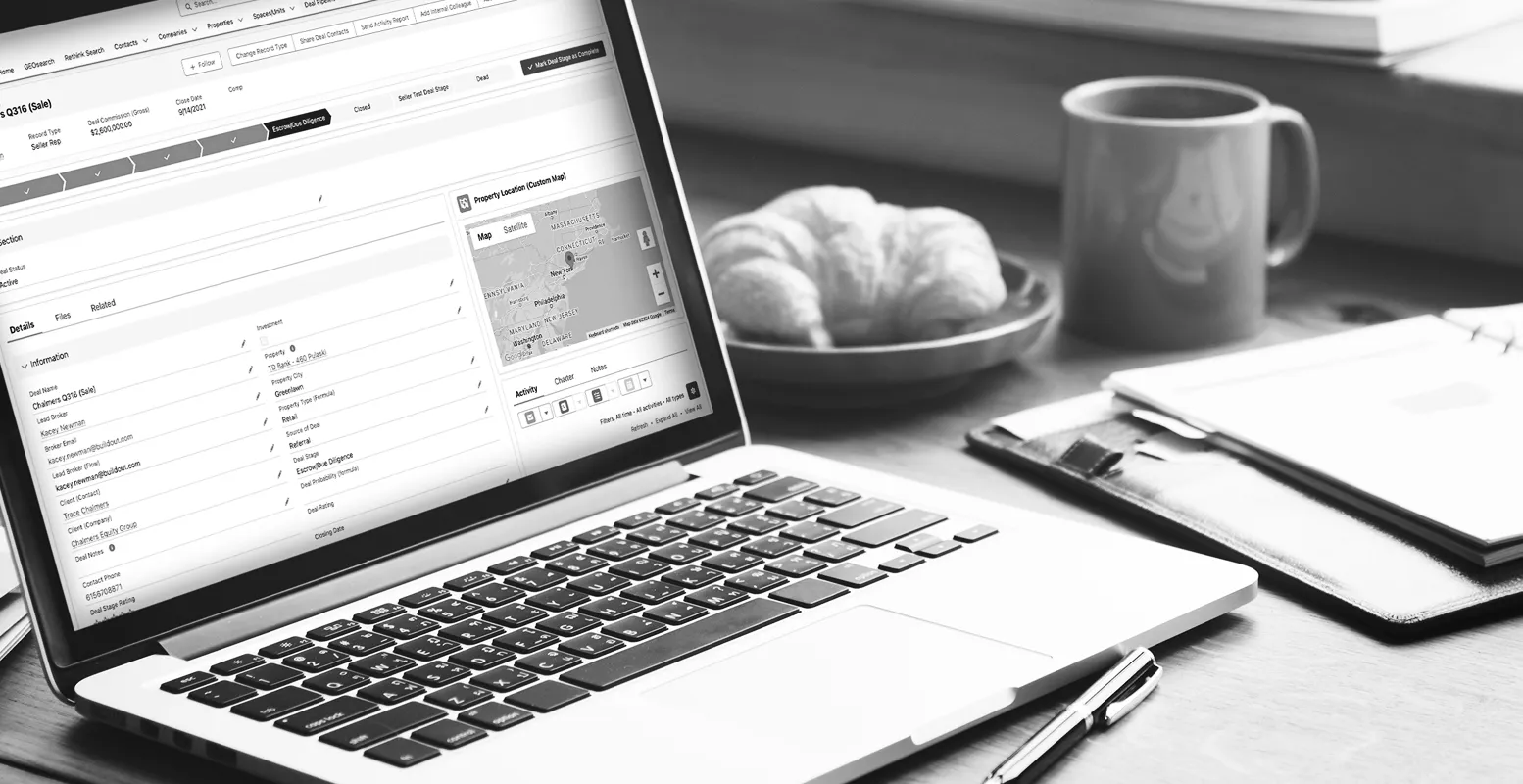 Laptop computer on a table with a mock-up of Buildouts Rethink CRM showing