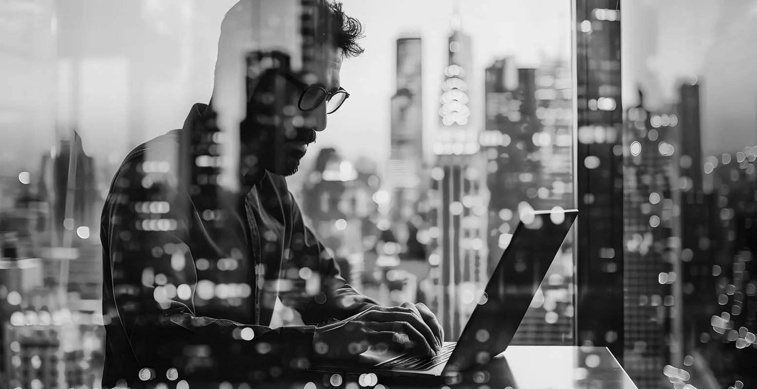 Man working on the computer with city skyline in background