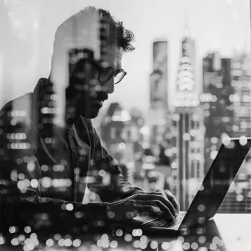 Man working on the computer with city skyline in background