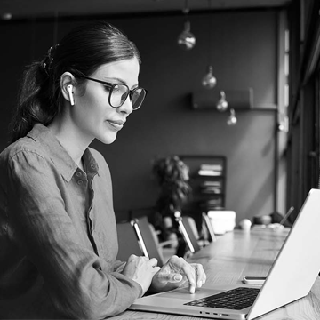 Female marketing professional working on computer looking out a window