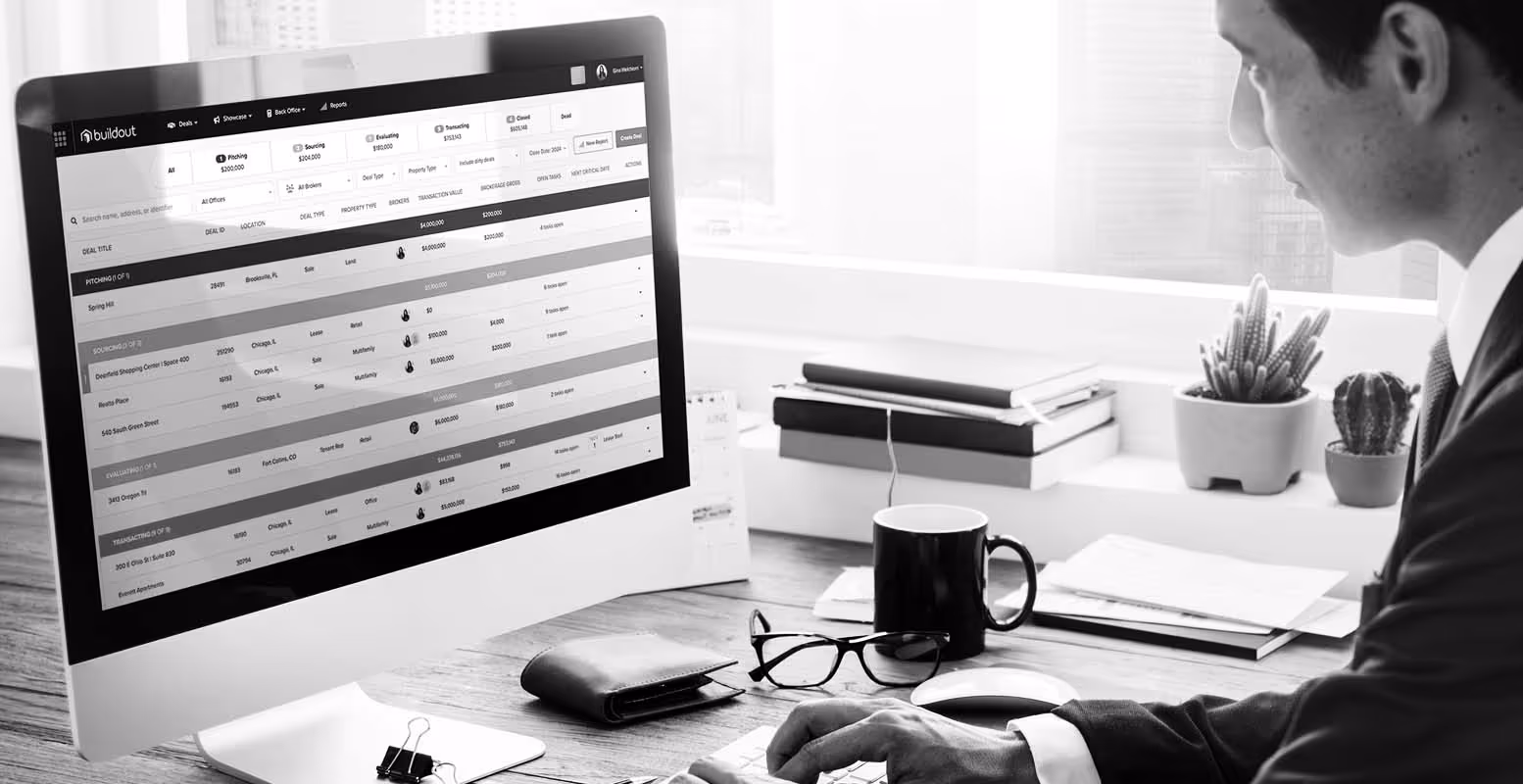 Man sitting on computer showing a mock-up of Buildout Manage & Close
