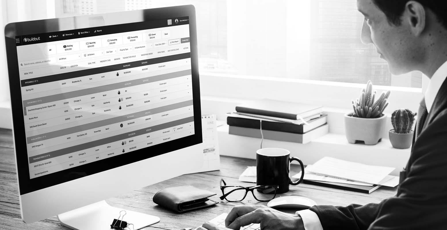 Man sitting on computer showing a mock-up of Buildout Manage & Close
