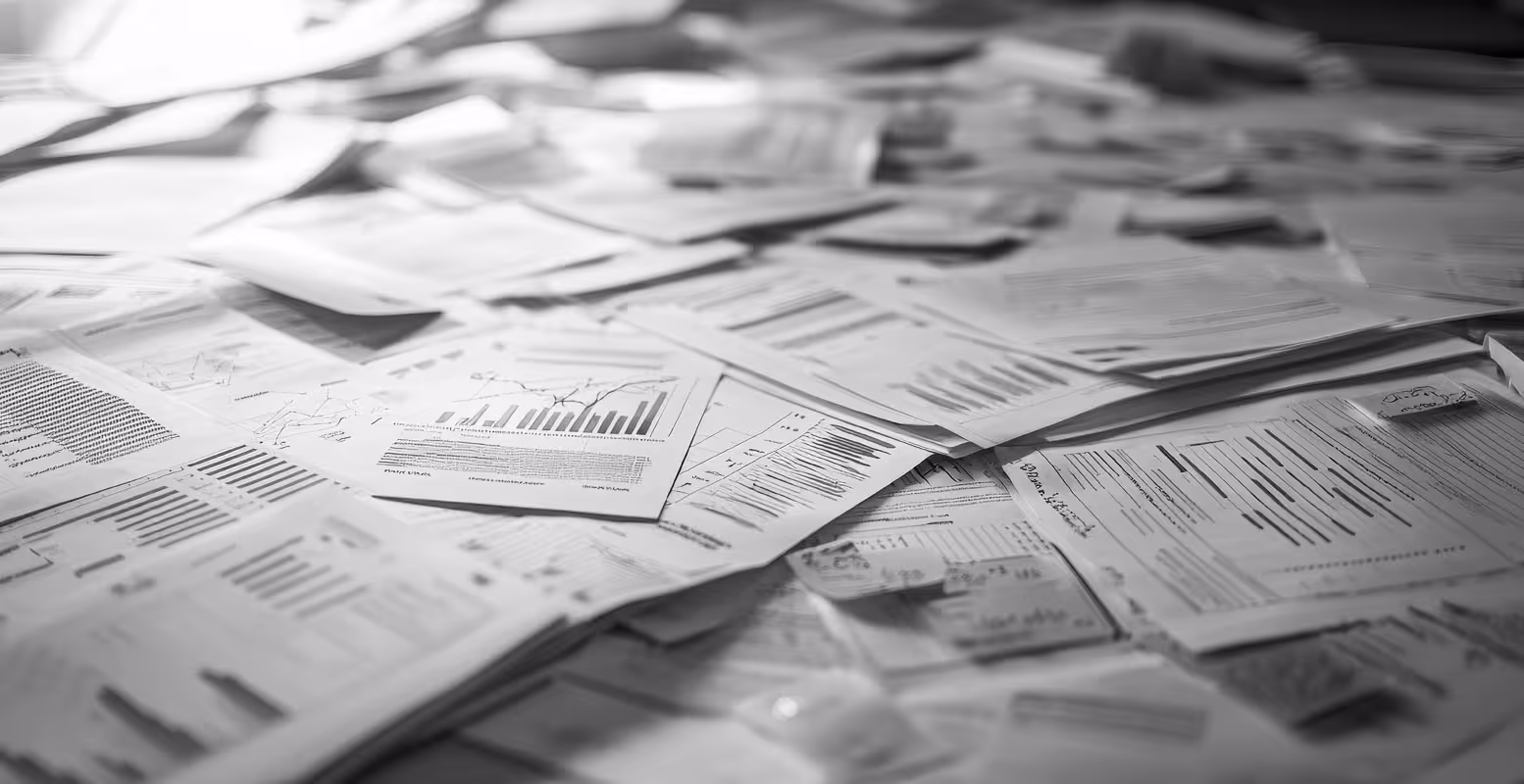 Unmanageable pile of financial papers on a desk