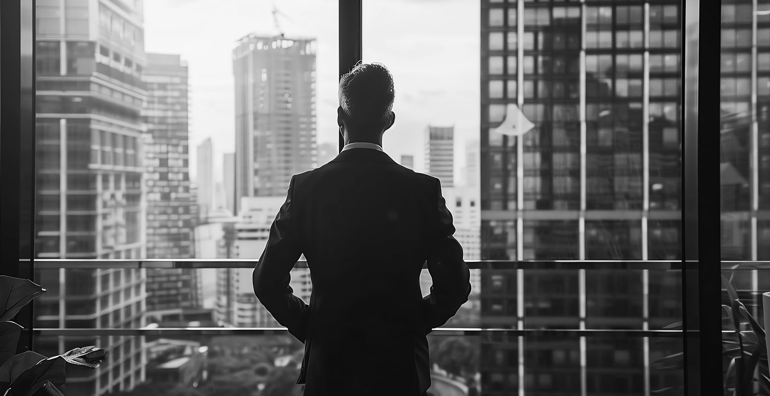 Business man looking out office window at city skyline