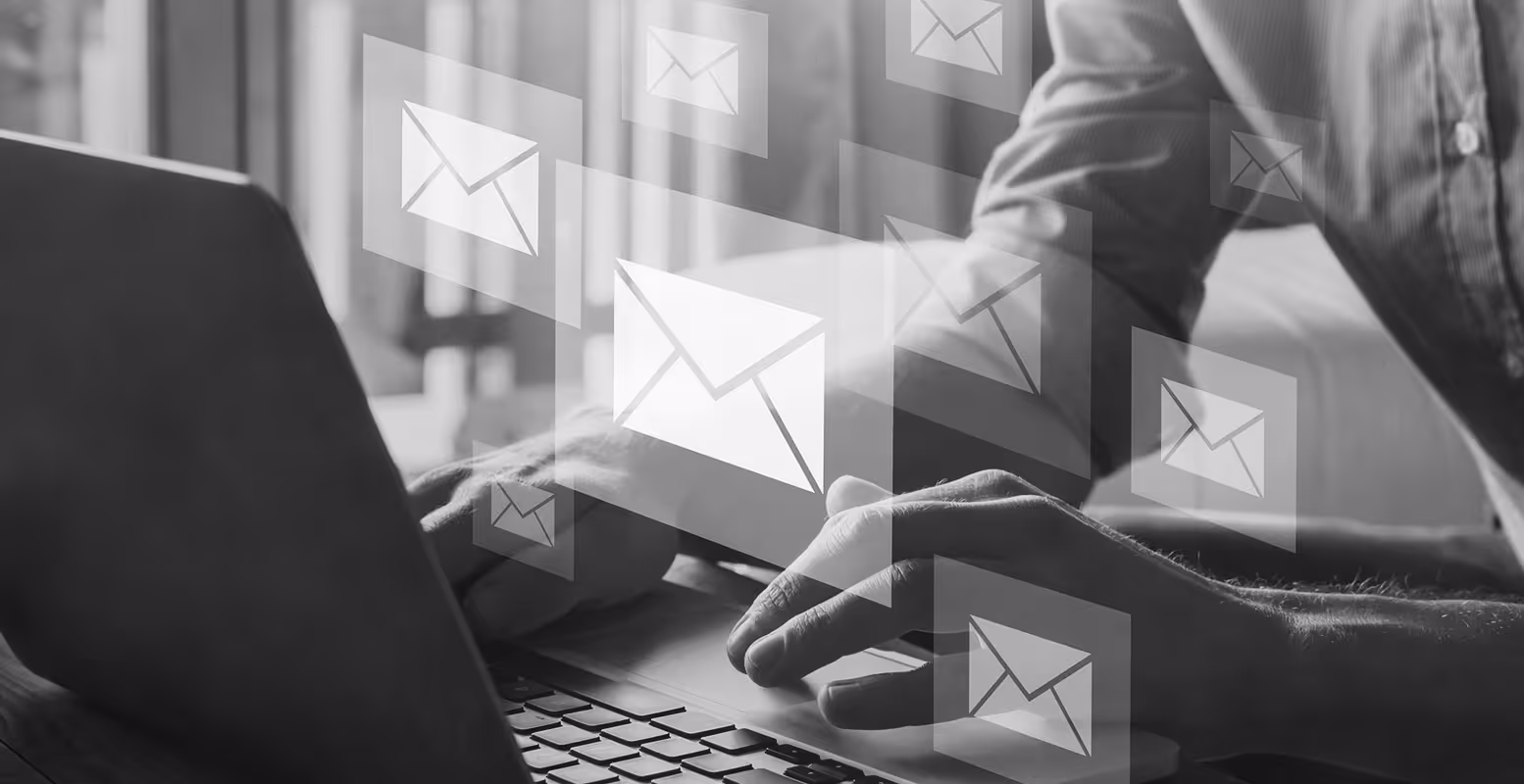 Man at laptop typing with email envelope symbols