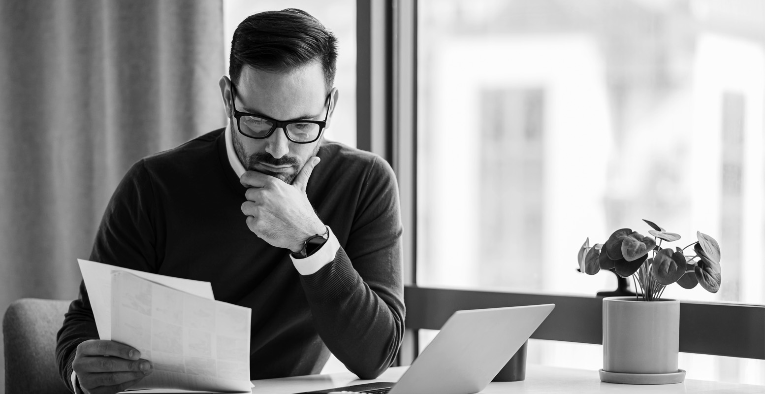 man at desk looking at papers