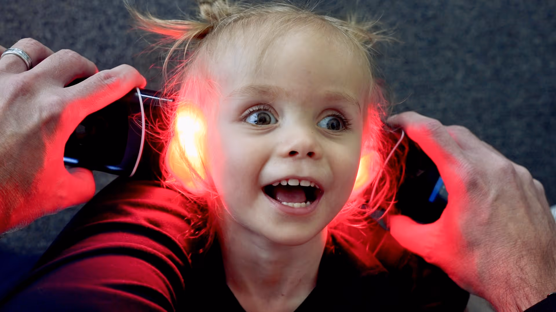 Excited young child receiving red laser therapy at NeuroSolution Center of Austin, Texas.