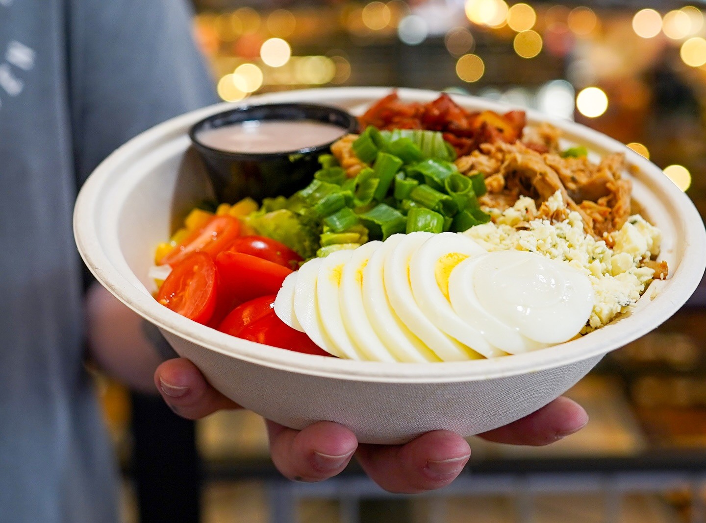 A person holding a bowl of Cobb salad at Forage Kitchen, Milwaukee.