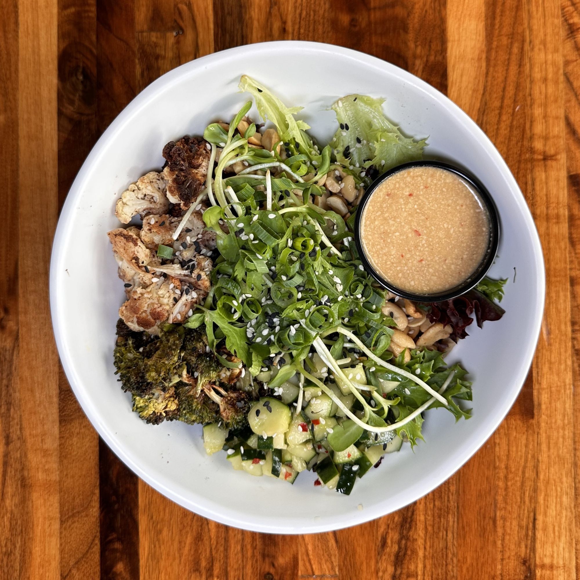  A Cashew bowl from Forage Kitchen with roasted cauliflower and broccoli, fresh greens, and a side of cashew dressing.