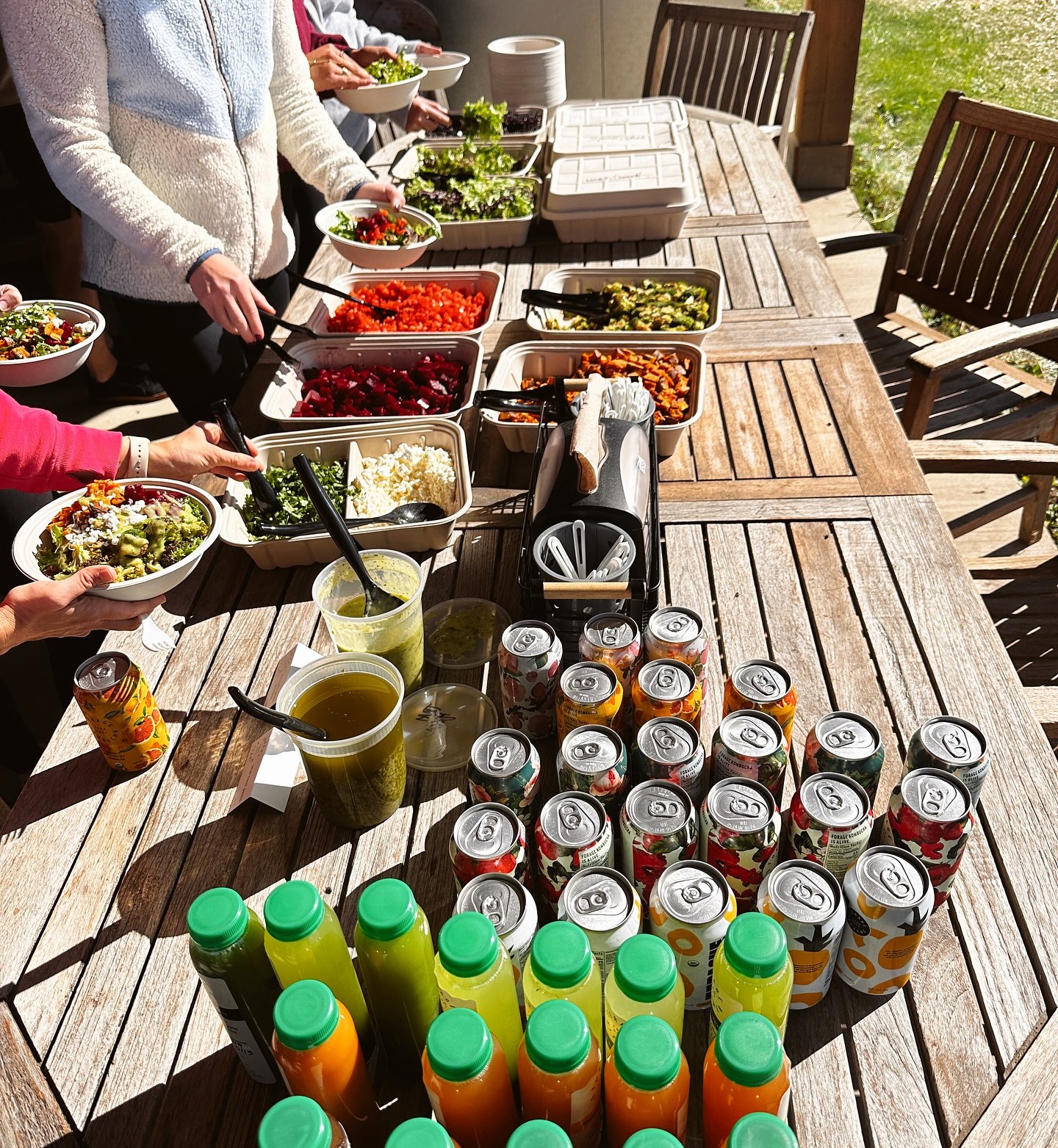  People making their own bowls with fresh ingredients kept on the table, along with beverages from Forage Kitchen catering.