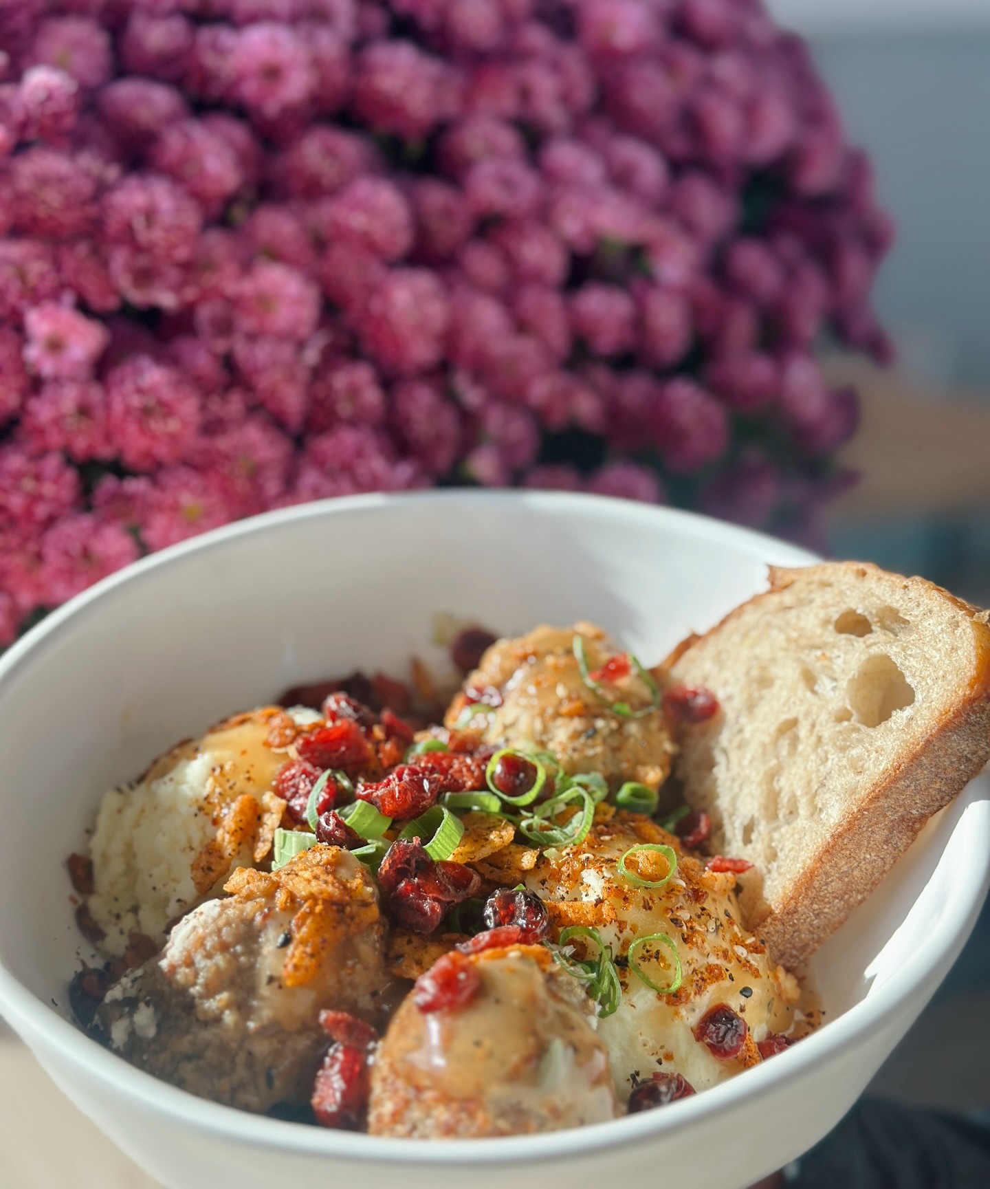 Forage Kitchen Thanksgiving bowl with turkey meatballs, sweet potatoes, green onions, cranberries, and a slice of local sourdough bread.